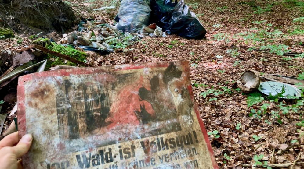 Müllsammeln im Wald und Finden alter NS-Parolen