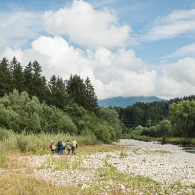 Menschen in der bewaldeten Flusslandschaft