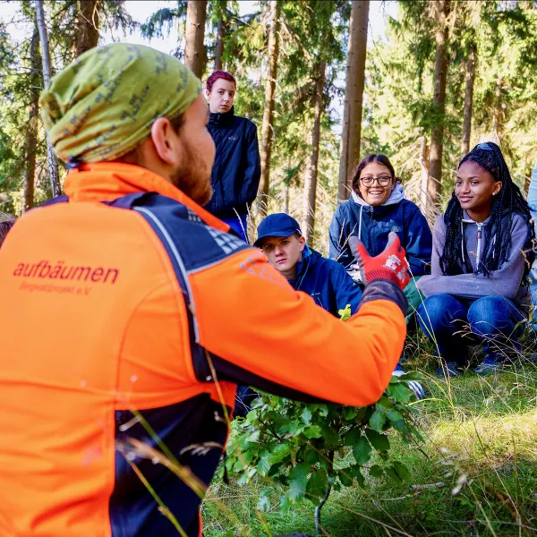 Bergwaldprojekt-Förster spricht zu Jugendlichen im Wald