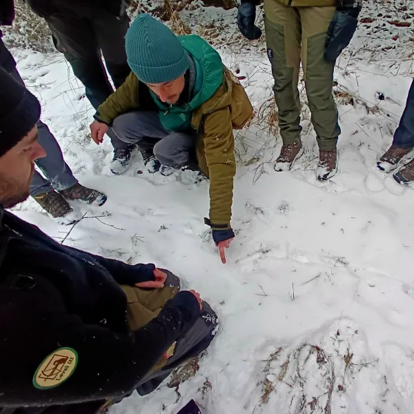 Ein Mann zeigt im Schnee eine vermeintliche Wildspur